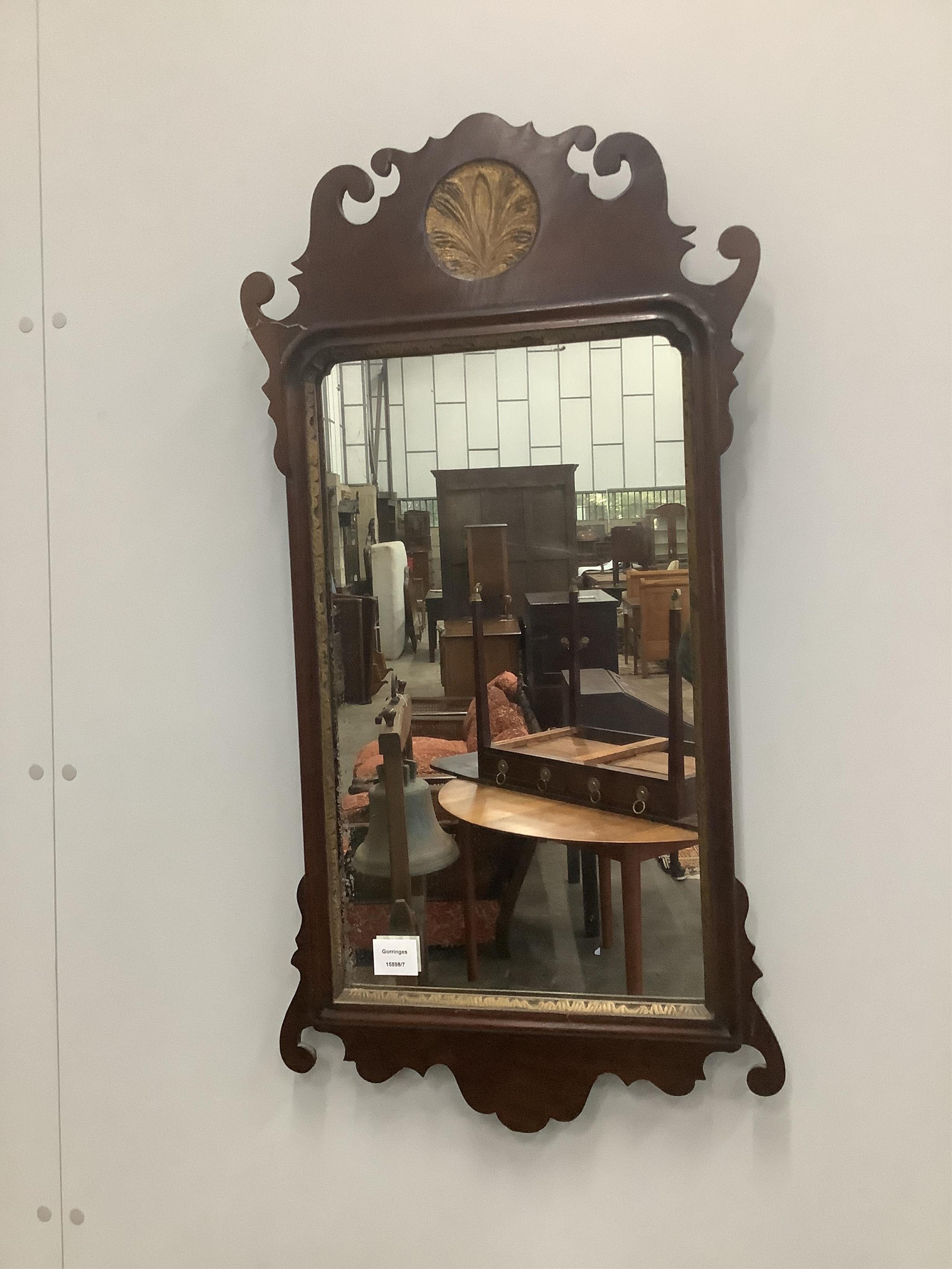 A George III style parcel gilt mahogany fret cut wall mirror, width 44cm, height 86cm. Condition - fair